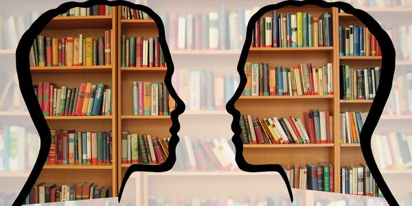 Symbolbild Shilouette zweier Köpfe über Bücherregal