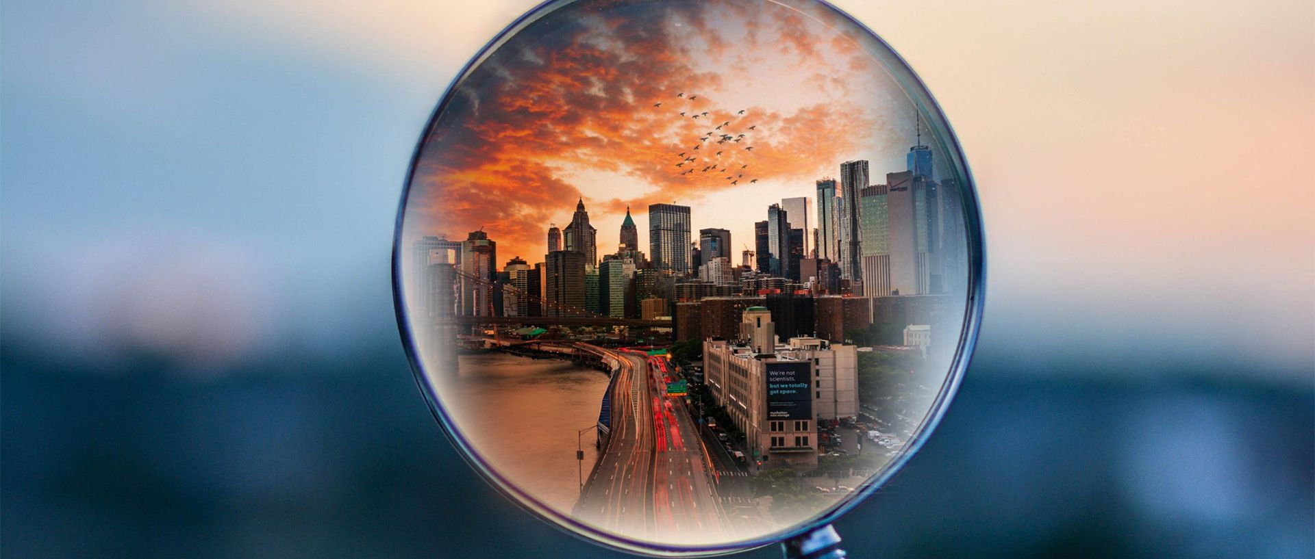 Symbolbild Blick durch Lupe auf Großstadt