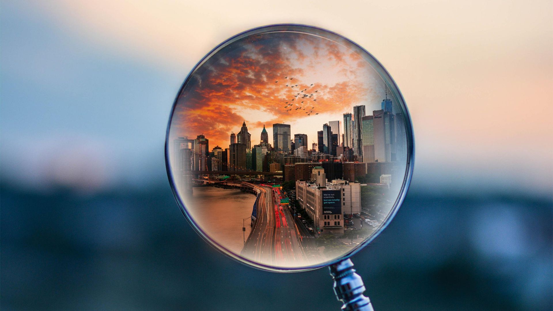 Symbolbild Blick durch Lupe auf Großstadt